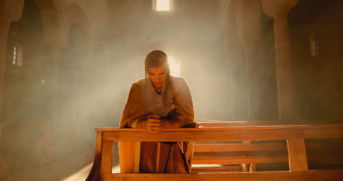 Young viking man prays in a large church