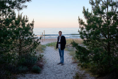 Full length of man standing on shore against sky