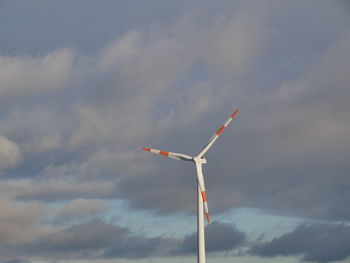 Low angle view of windmills against sky