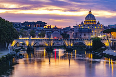 Arch bridge over river against buildings in city