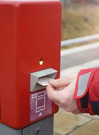 Close-up of man putting paper in mailbox