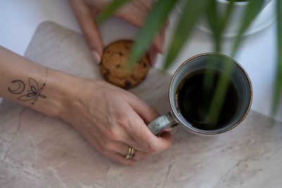 High angle view of hand holding drink on table