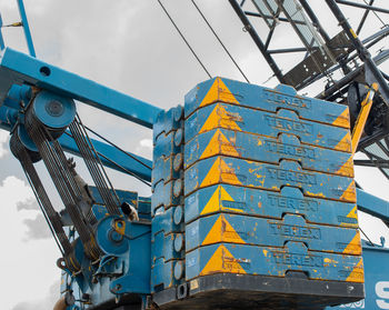 Low angle view of crane at construction site against sky