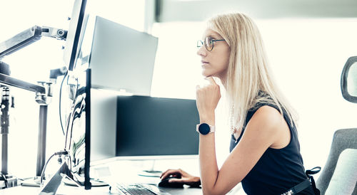 Portrait of young woman using mobile phone while sitting at home