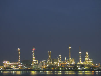 View of illuminated refinery in night scene after sunset