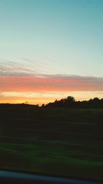 Scenic view of silhouette field against sky during sunset
