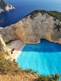 Rock formation against sea in sunny day