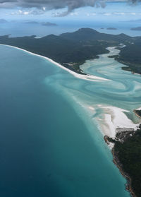 Aerial view of sea and mountains against sky