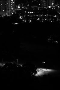 High angle view of illuminated street by buildings at night