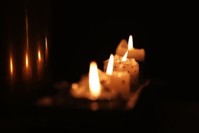 Close-up of burning candle in darkroom