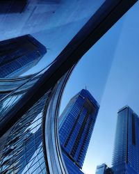 Low angle view of modern buildings against clear blue sky