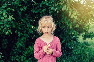 Portrait of a boy standing against plants