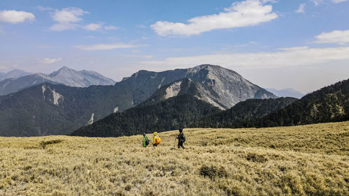 People hiking with mountains