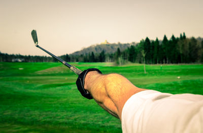 Cropped hand of man holding golf club