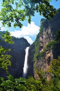 Scenic view of waterfall against sky