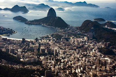 High angle view of townscape by sea against sky