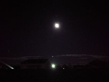 Low angle view of illuminated moon against sky at night