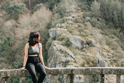 Rear view of woman standing on rock