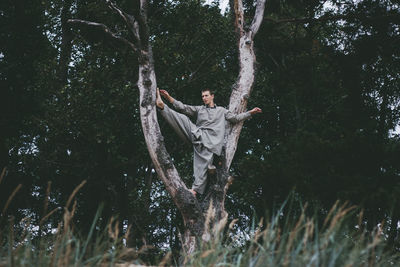 Young man climbing on tree