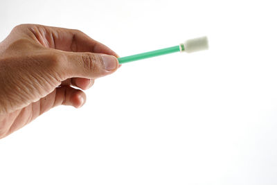 Close-up of hand holding paper against white background