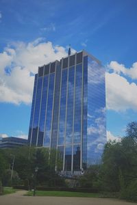 Low angle view of modern building against cloudy sky