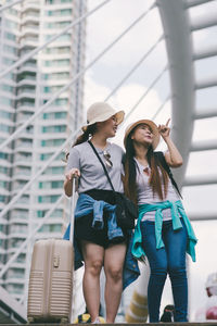 Women wearing hat standing against built structure