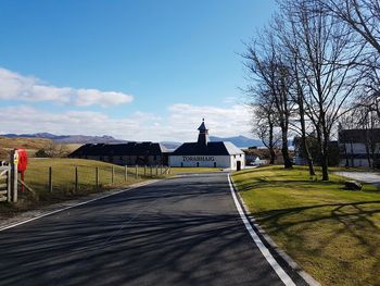 Road amidst buildings against sky