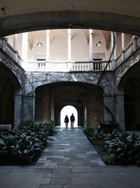 Silhouette couple seen through arch in building