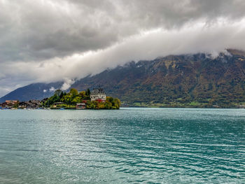 Scenic view of sea by mountains against sky