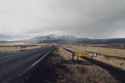 Road leading towards mountains against sky