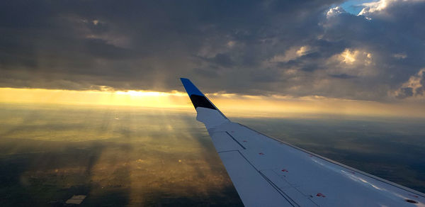Airplane flying in sky during sunset
