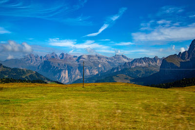 Scenic view of landscape and mountains against blue sky