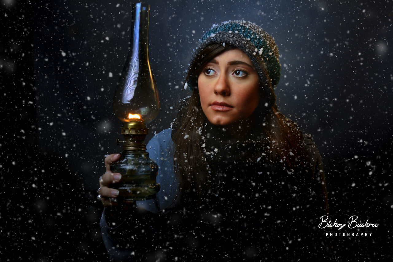 night, one woman only, one person, adult, only women, cold temperature, adults only, one young woman only, winter, young adult, portrait, people, looking at camera, beautiful woman, holding, witch, beauty, snowing, beautiful people, outdoors, young women, black background, warm clothing, close-up