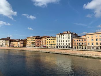 River by buildings in city against sky