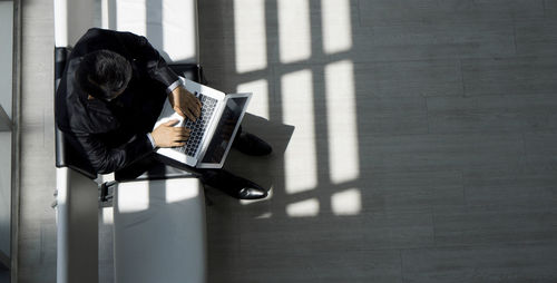 Man using mobile phone while sitting on table