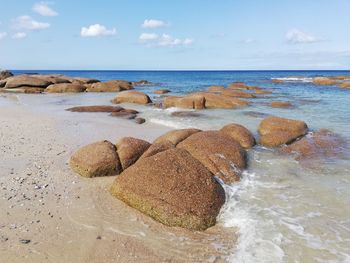 Scenic view of rocks on beach against sky