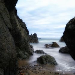 Scenic view of rocks in sea against sky