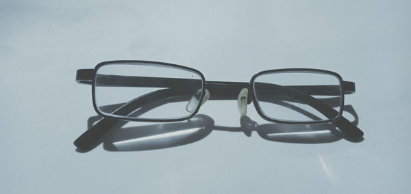 Close-up of eyeglasses on table against white background