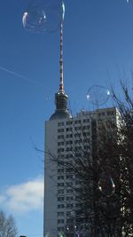 Low angle view of communications tower against blue sky
