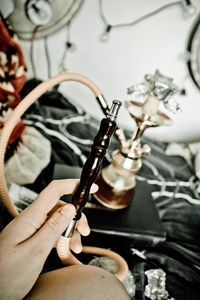 Cropped hand of person holding hookah pipe