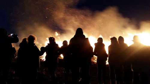 Silhouette people by easter fire at night