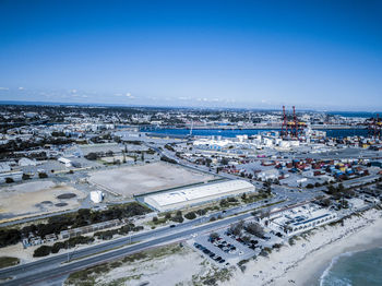 High angle view of city buildings against blue sky