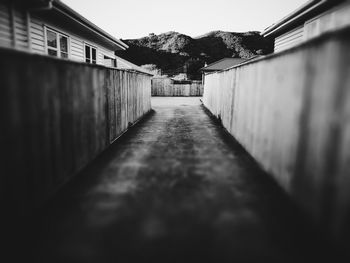 Surface level of footpath amidst buildings against sky