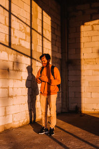 Full length of man standing against wall