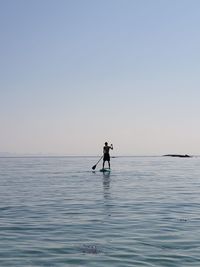 Man surfing in sea against clear sky
