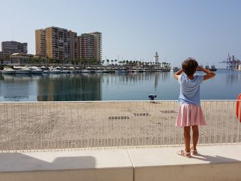 Rear view of girl standing on promenade in city