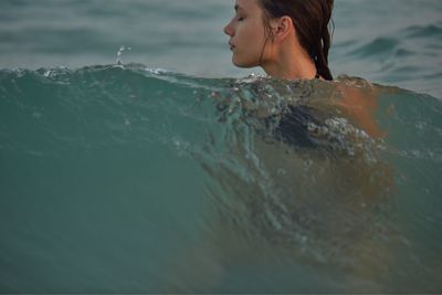 Young woman with eyes closed in sea