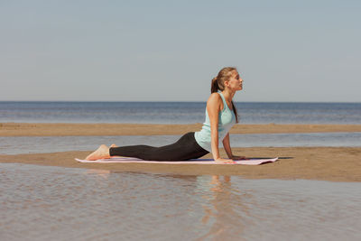 Rear view of woman standing at beach