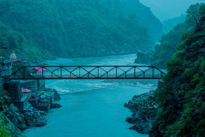 Bridge over sea against trees