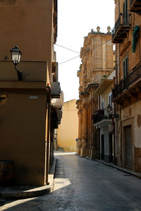 Street amidst buildings in city against clear sky